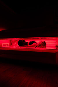 Side view of a woman lying down in a full-body red light therapy bed at The Tanning Shop Ireland.