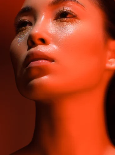 Red light treatment glowing on relaxed female face