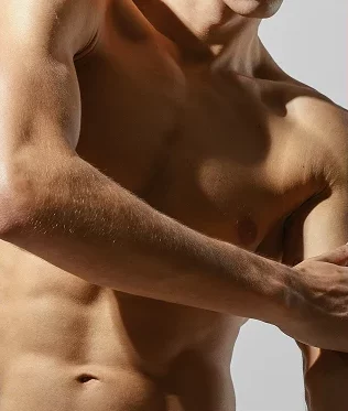 Man applying lotion to tattooed arm in skin care routine