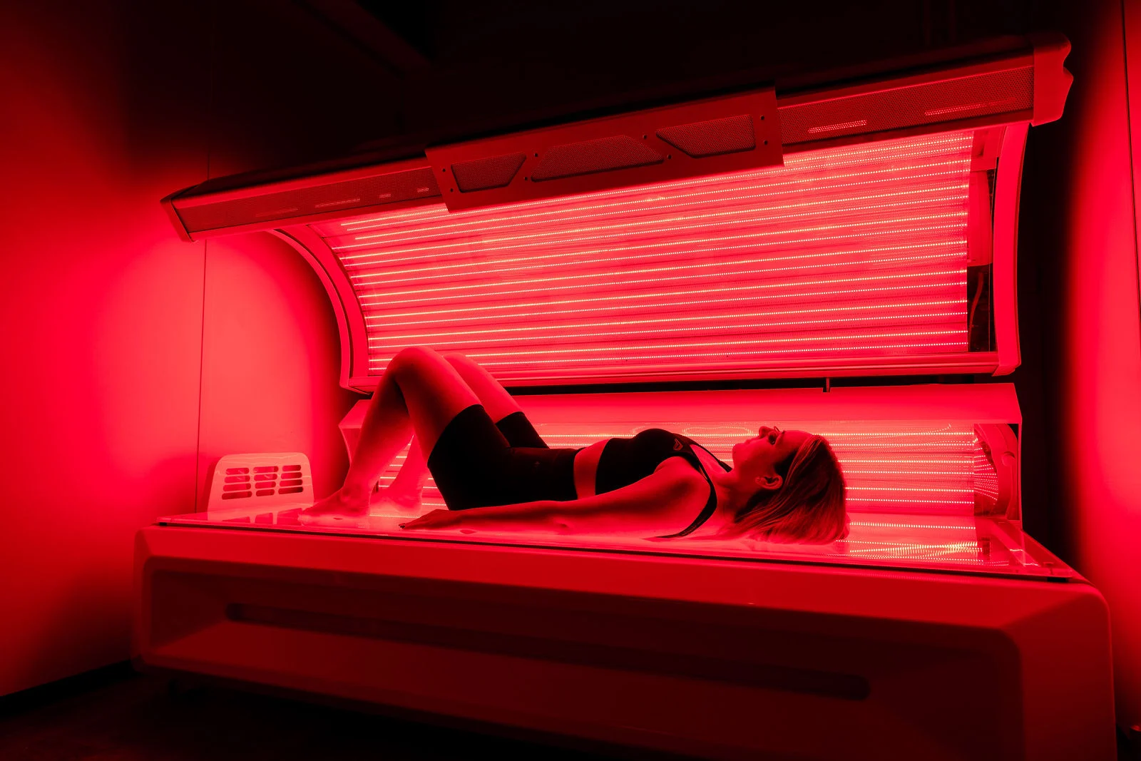 Side view of a woman lying down in a full-body red light therapy bed in Dublin, Ireland