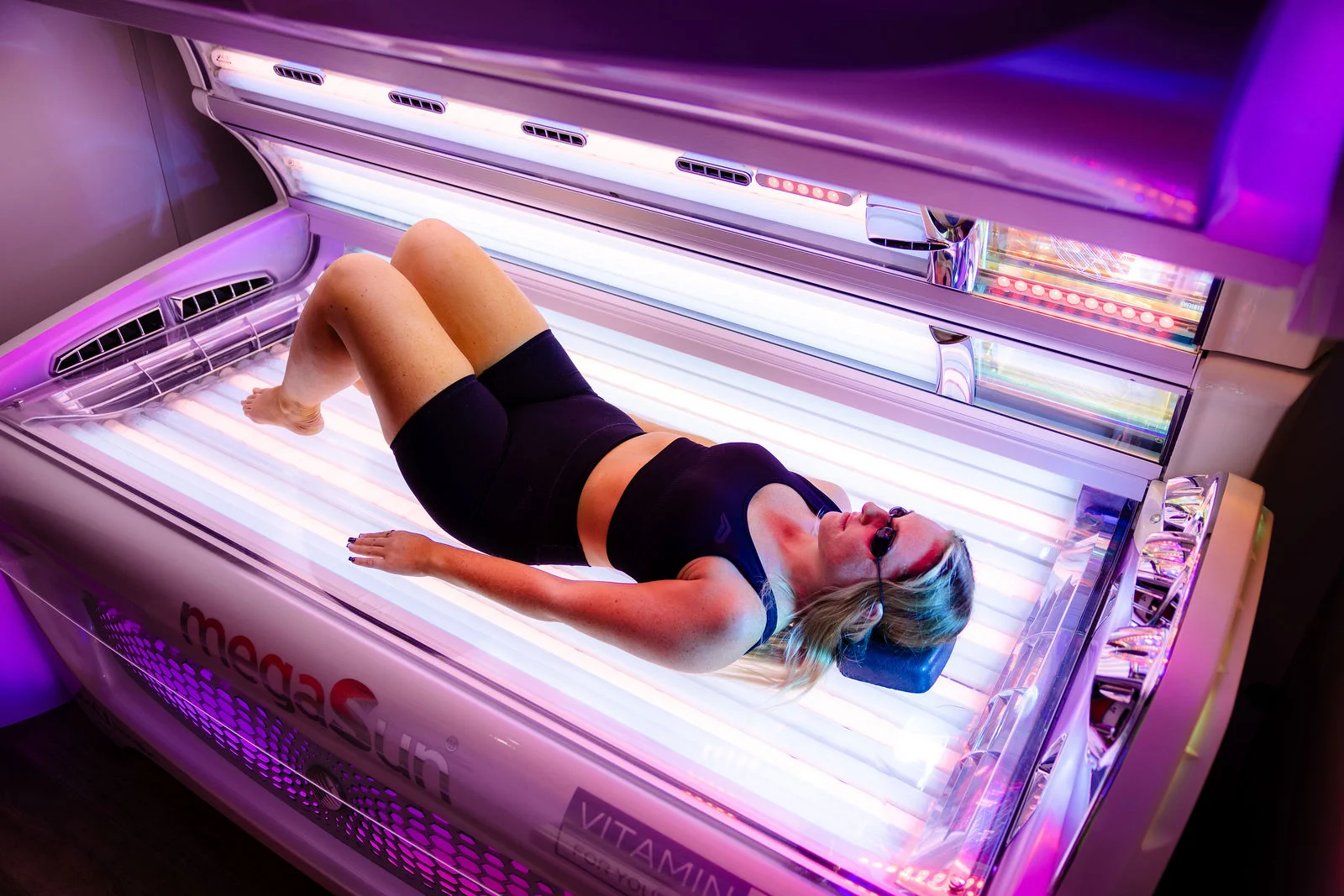 Client practicing responsible UV tanning in Ireland wearing mandatory protective eyewear