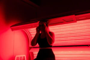 Customer putting on eye protection while preparing for a red light therapy session at The Tanning Shop Ireland Customer putting on eye protection while preparing for a red light therapy session at The Tanning Shop Ireland