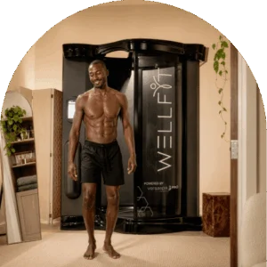 Smiling Customer Stepping Out Of A Wellfit Spray Skincare Booth After A Full Body Skin Treatment At The Tanning Shop