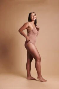 Smiling woman in swimwear with an even, natural-looking tan – WellFit skincare and Tanning Shop spray tan combined.