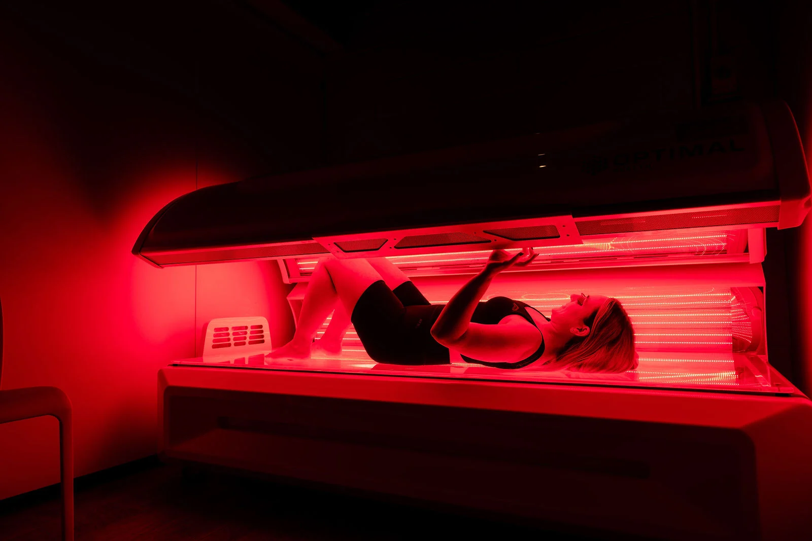 Woman lying in a red light therapy bed during a treatment session. Woman lying in a red light therapy bed during a treatment session.
