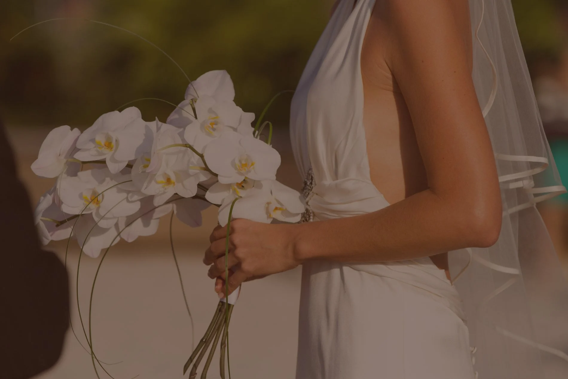 Bride with a tan holding a bouquet of flowers Bride with a tan holding a bouquet of flowers